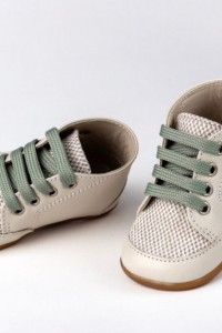 Baby boots for first steps made of leather and fabrics with with shoelace